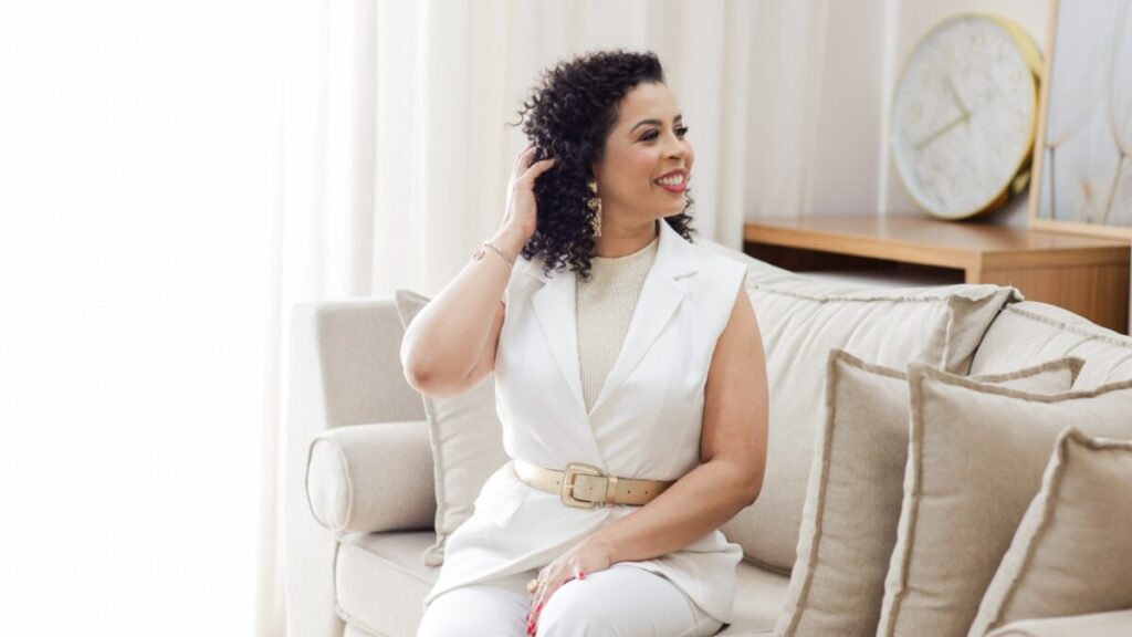 Daniele Barros, psicóloga, sentada no sofá