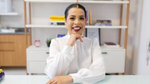 Daniele Barros, psicóloga, sorrindo em seu escritório